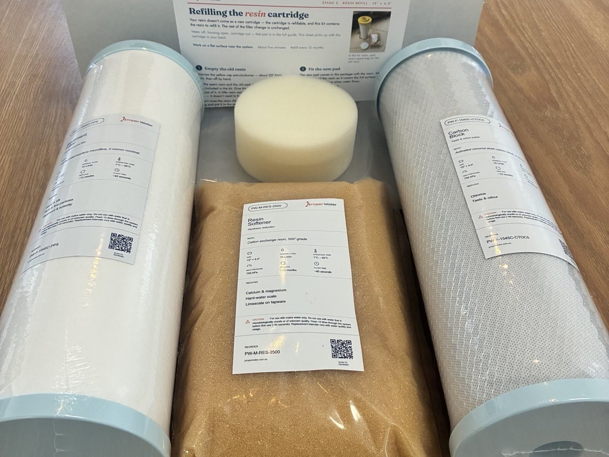 Complete Home Filtration compatible filter kit unboxed, cartridges, resin bag, pad, instructions and grease sachet